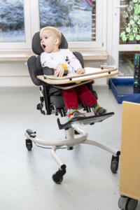 Kind mit Behinderung sitzt in Therapiestuhl von Schuchmann