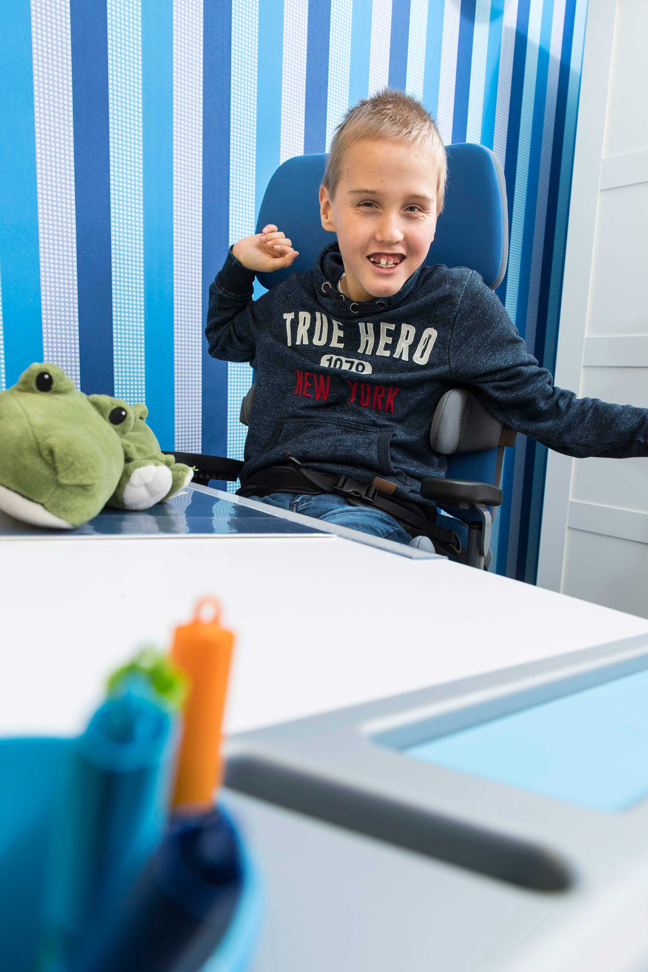 Kind mit Behinderung sitzt in Therapiestuhl von Schuchmann