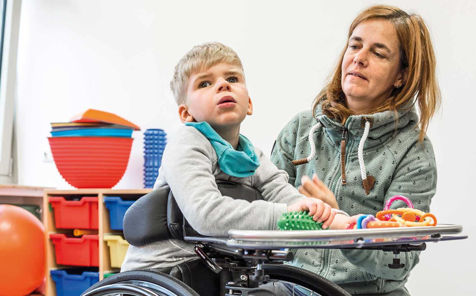 Kind mit Behinderung steht im Stehtrainer von Schuchmann