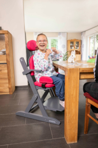 Kind mit Behinderung sitzt in einer Sitzhilfe von Schuchmann