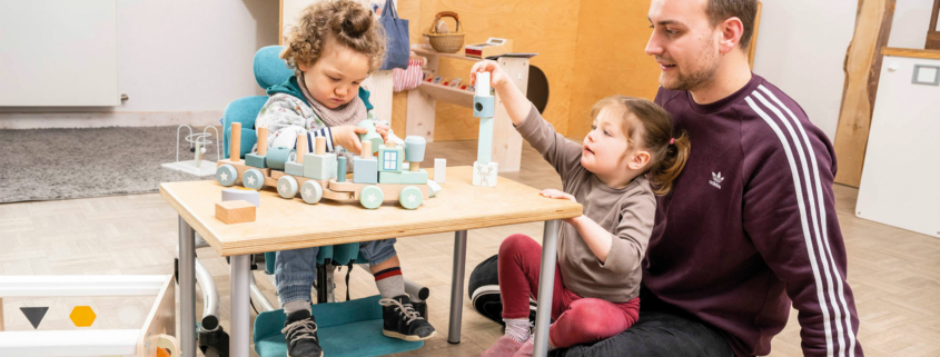 Kind mit Behinderung spielt im Therapiestuhl von Schuchmann