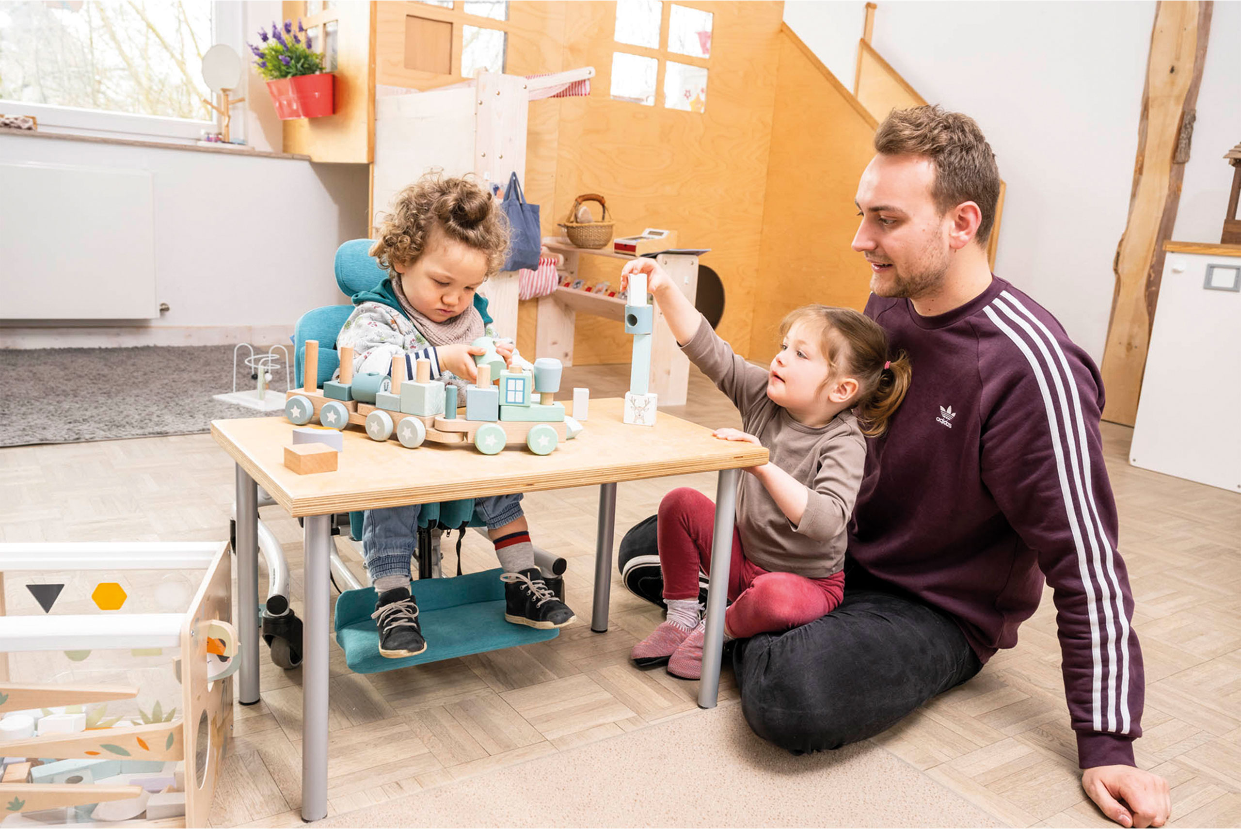 Kind mit Behinderung spielt im Therapiestuhl von Schuchmann
