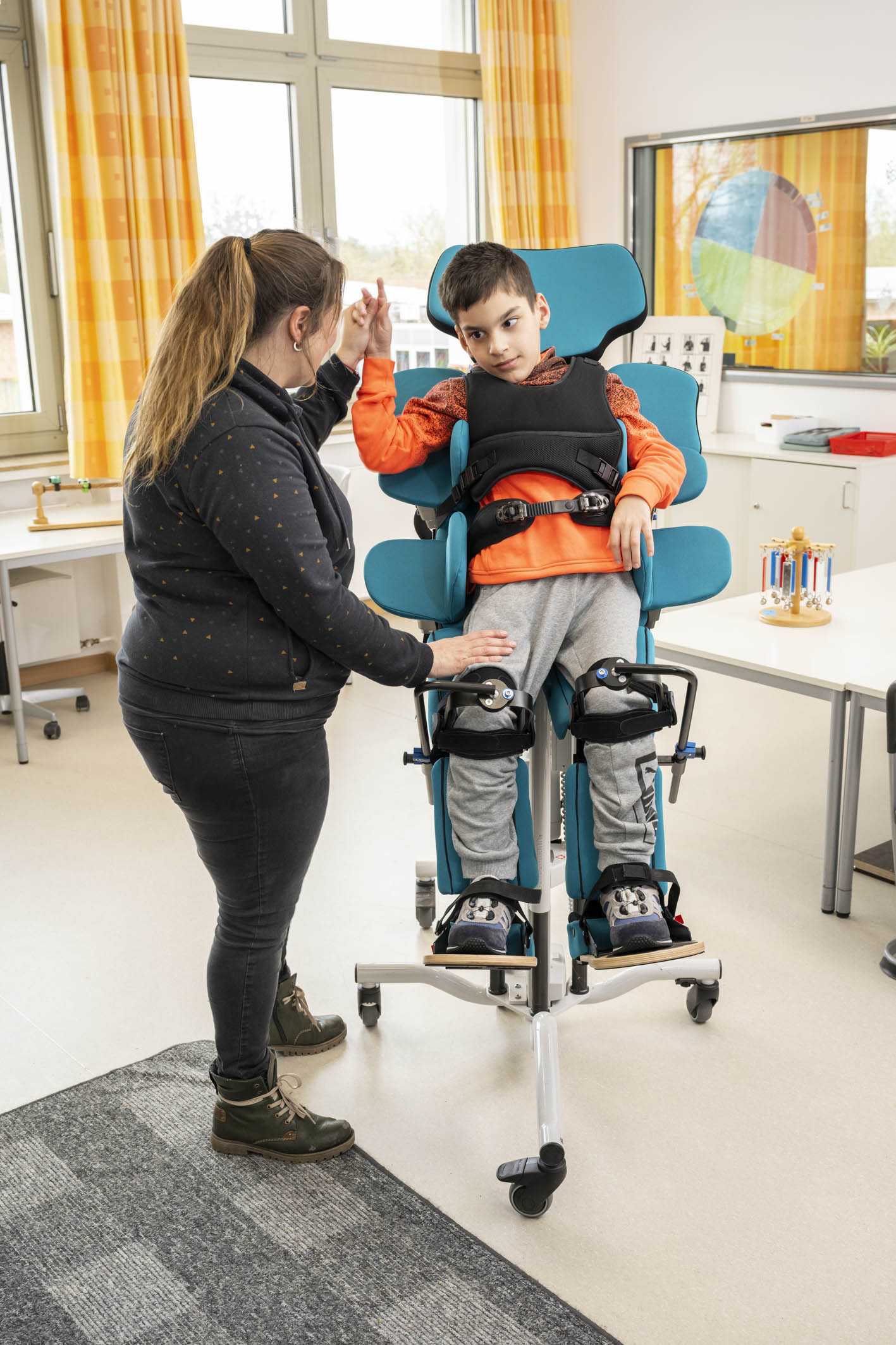 Kind mit Behinderung steht im anpassungsfähigen Schrägliegesystem von Schuchmann