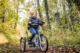 Ein Mädchen mit Behinderung sitzt auf dem momo dreirad. Einem Fahrrad für Kinder mit Behinderung.